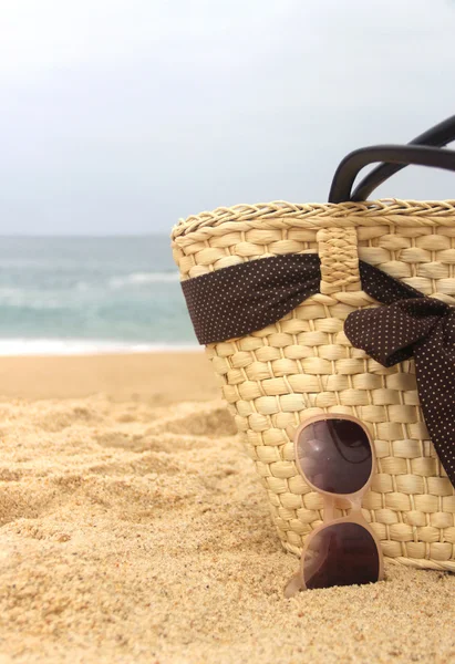 Seacoast, straw beach bag and sunglasses — Stock Photo, Image