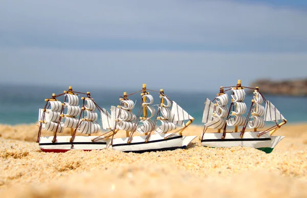 Funny small toy sailing ships on the beach — Stock Photo, Image