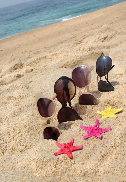 Quatre paires de lunettes de soleil sur la plage — Photo