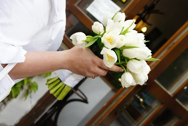 Buquê de casamento de tulipas brancas na mão da noiva — Fotografia de Stock