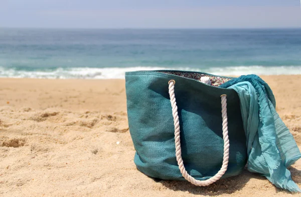 Голубая пляжная сумка на берегу моря и платок — стоковое фото