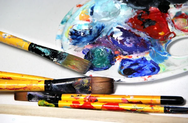 Art palette and paintbrushes — Stockfoto