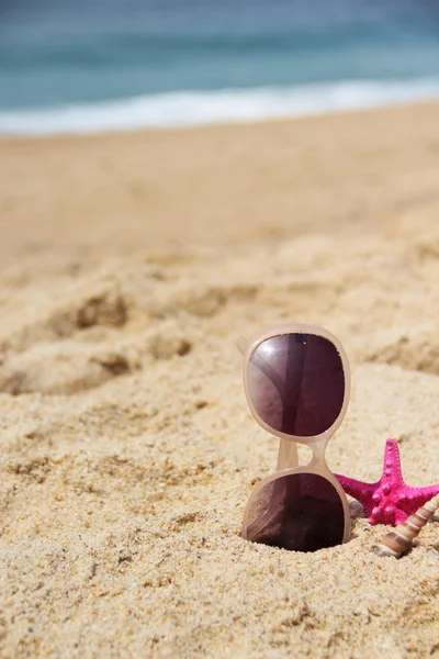 Empty sandy beach and sunglasses — Stock Photo, Image