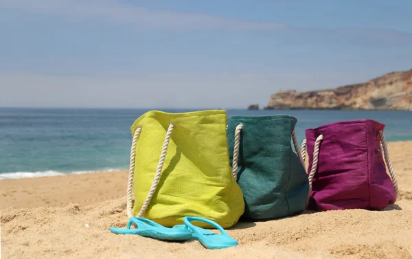 Des sacs de plage multicolores vifs au bord de la mer — Photo