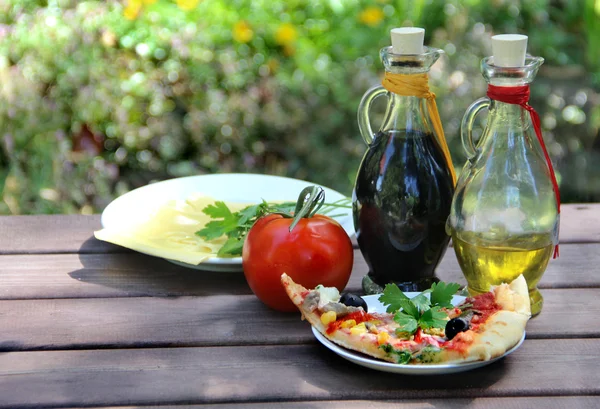 Pedazo de pizza en la mesa de jardín de verano — Foto de Stock
