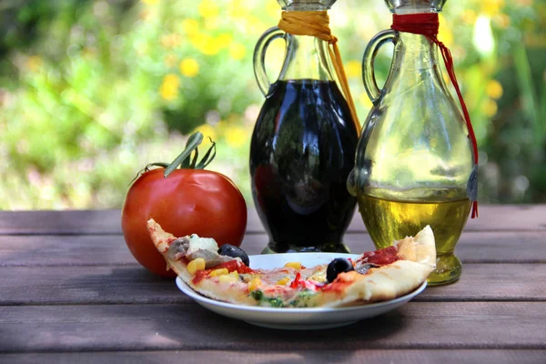 Bit av pizza i tabellen sommar trädgård — Stockfoto