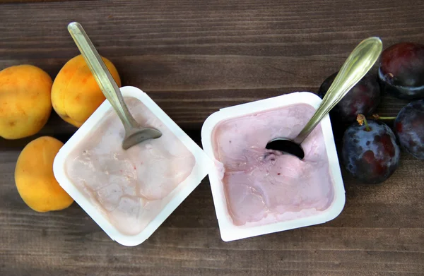 Yoghurts on the wooden table — Stock Photo, Image