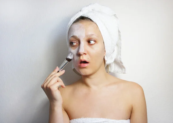 Young beautiful woman with clay facial mask on her face — Stock Photo, Image