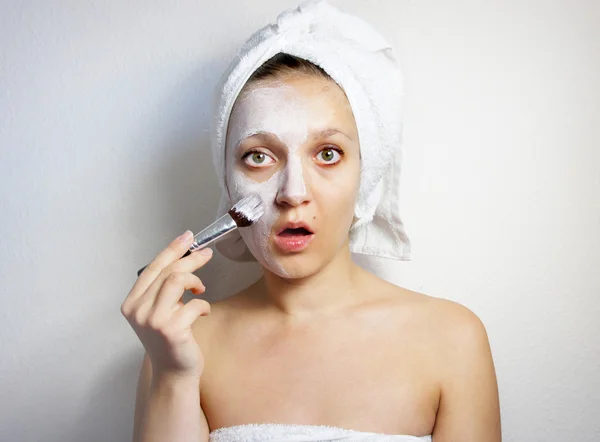 Young beautiful woman with clay facial mask on her face — Stock Photo, Image