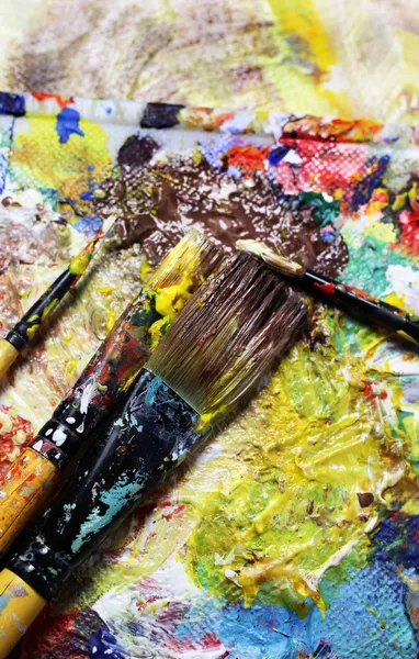 Beautiful vivid art palette and mix of paintbrushes — Stock fotografie