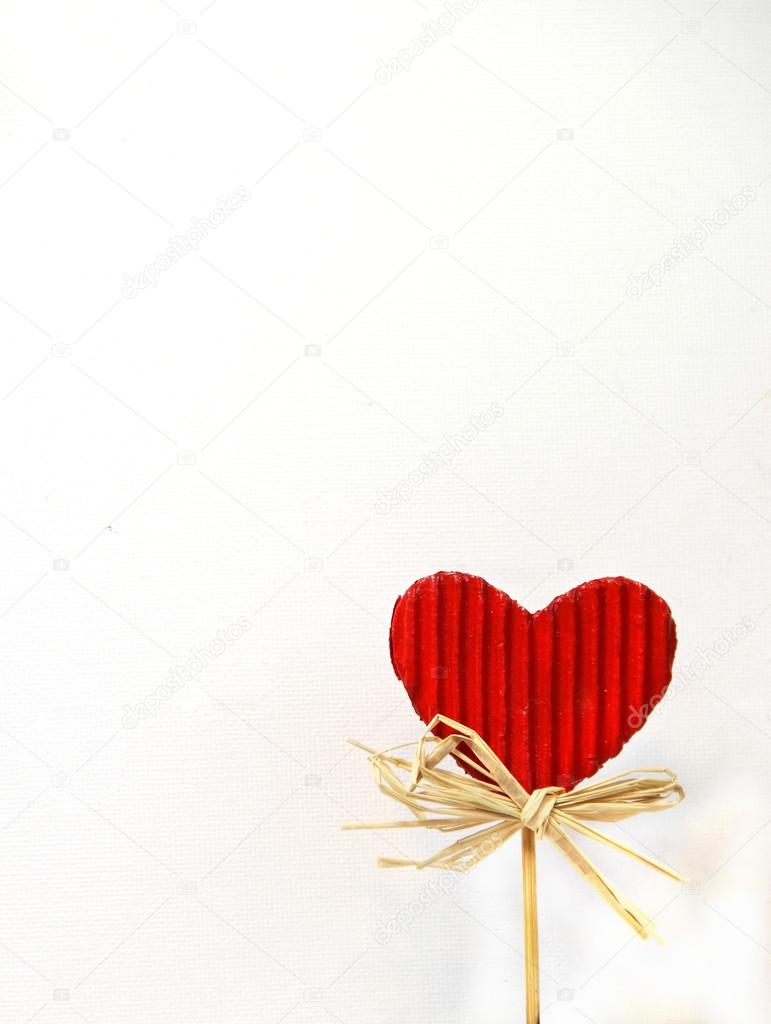Red paper heart on the stick on white background