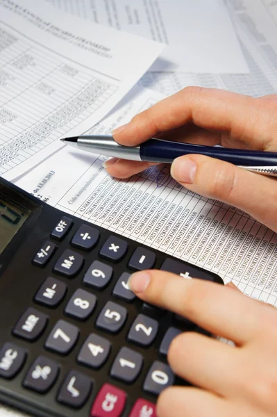 Office table with calculator, pen and accounting document — Stock Photo, Image