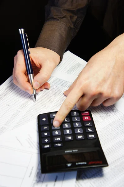 Office table with calculator, pen and accounting document — Stock Photo, Image