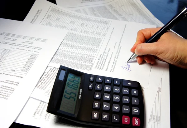 Office table with calculator, pen and accounting document — Stock Photo, Image