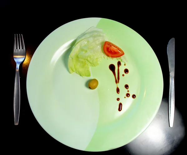 Big plate with a small piece of food — Stock Photo, Image