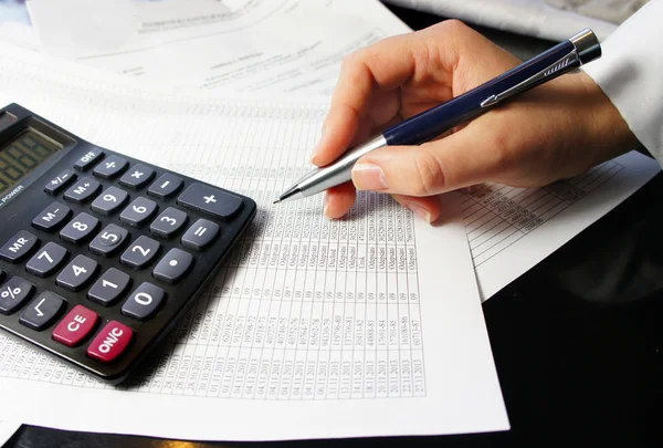 Office table with calculator, pen and accounting document — Stock Photo, Image