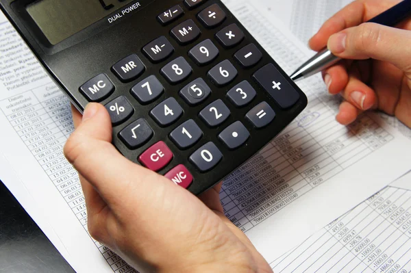 Office table with calculator, pen and accounting document — Stock Photo, Image