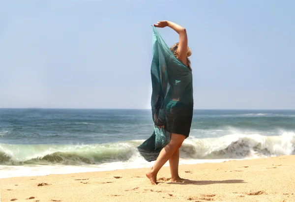 Mulher sorridente bonita na praia com xale — Fotografia de Stock