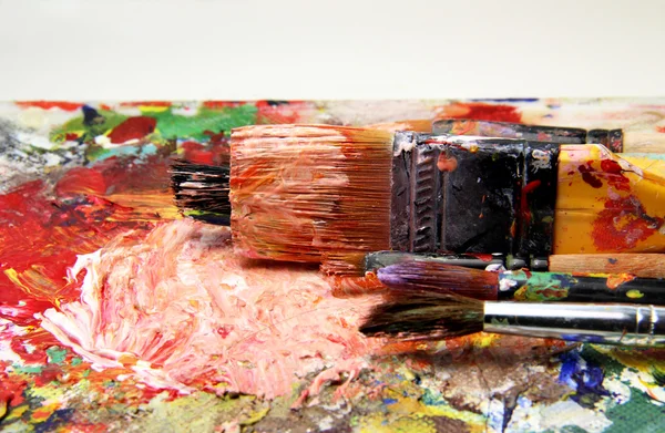 Beautiful vivid art palette and mix of paintbrushes — Stock fotografie
