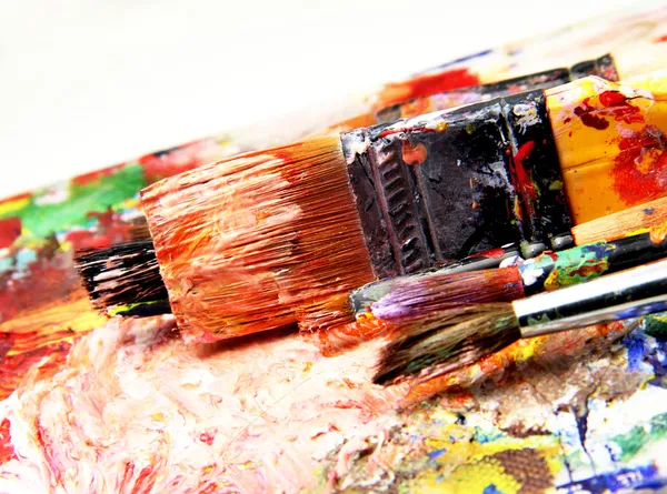 Beautiful vivid art palette and mix of paintbrushes — Stock Photo, Image