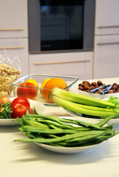 Assiettes avec des aliments sains sur la table de cuisine blanche — Photo