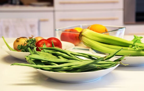 Assiettes avec des aliments sains sur la table de cuisine blanche — Photo