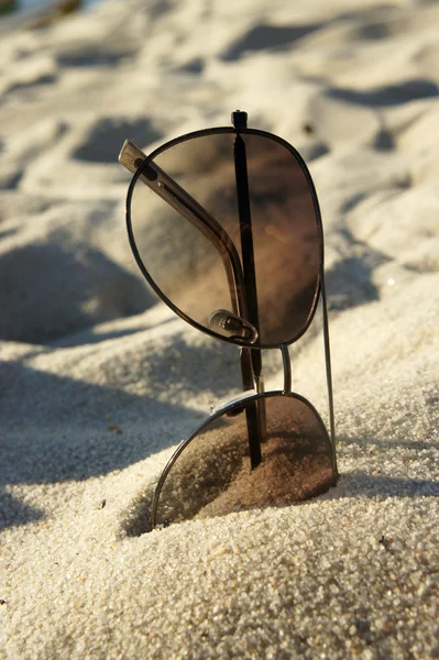 Женские солнечные очки на пляже, солнце и песок — стоковое фото