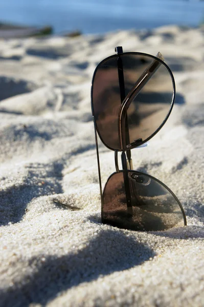 Kvinnliga solglasögon på stranden, solen och sanden — Stockfoto