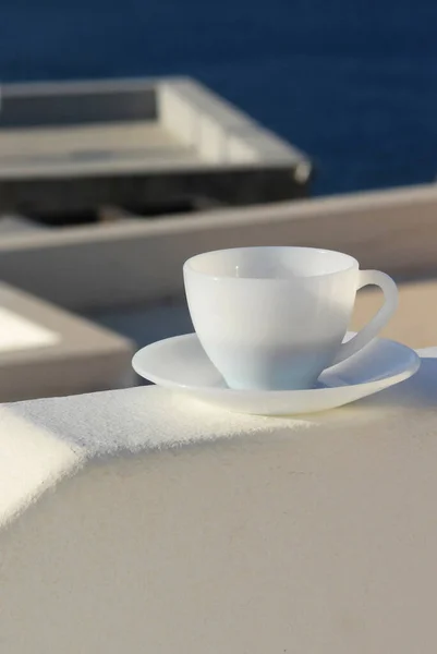 Sea and morning cup of coffee in the white mug
