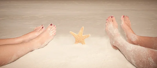 Sandiga fötter med sjöstjärna — Stockfoto