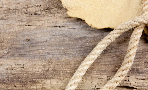 Cuerda y cuero en mesa de madera — Foto de Stock