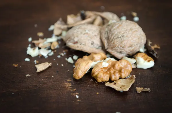 Nueces rotas sobre una mesa de madera —  Fotos de Stock