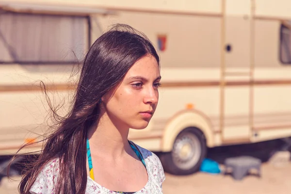 一个漂亮的少女站在一辆野营车前面的肖像 风吹着她的头发 复古的过滤照片 嬉皮士的样子 — 图库照片