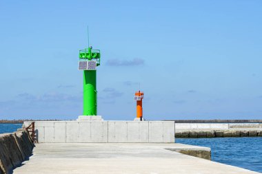 Kırmızı, yeşil ve güneş panelleri olan seyrüsefer kuleleri olan modern liman dalgaları