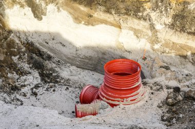 Yeni kanalizasyon kanalı inşaatı için yerin derinliklerindeki yeni geniş çaplı pvc kanalizasyon boruları ayırıcı.