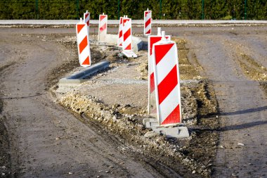 Şehirde yeni bir cadde oluşturulması, birçok kırmızı ve beyaz çizgili dikey yol bariyerlerinin ön görünümü