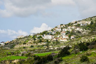 Kıbrıs Rum Kesimi 'nin güzel manzarası. Bir yamaçta pek çok özel ev var. Mavi gökyüzünün arka planında.