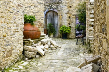traditional idyllic yard in a mountain village in Cyprus with large old terracotta amphora winery pot used as a flower pot