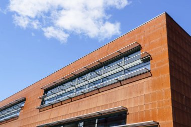 Paslı korten çelik paneller mavi bir gökyüzünün arka planında modern bir tasarım evinin ön cephesini kaplıyor.