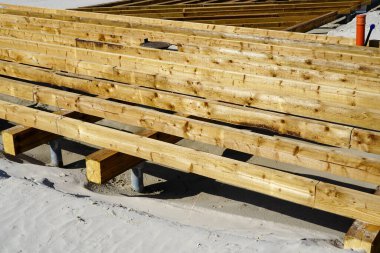 Kumlu bir sahilde yeni bir çam ağacından teras inşaatı