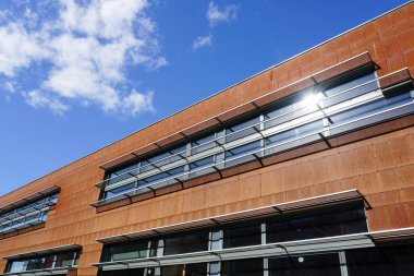 Paslı korten çelik paneller mavi bir gökyüzünün arka planında modern bir tasarım evinin ön cephesini kaplıyor.