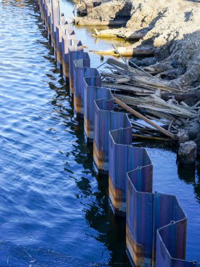 Nehir kıyısının güçlendirilmesi ve yeniden inşası sırasında geçici olarak bükülmüş çelik plaka muhafaza duvarı