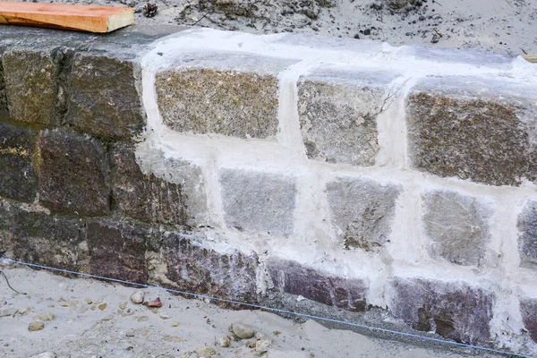 cleaning of cobblestone square stone walls and restoration of visual appearance of seams