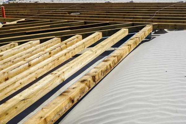 Construction of a new wooden board terrace on the sandy beach to improve the beach infrastructure