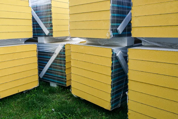 Sandwich panel packings on green grass, sustainable fiber material for thermal insulated industrial wall building