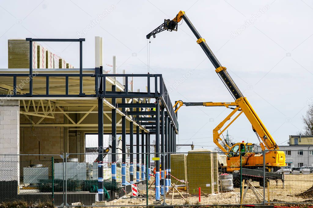 Assembly of a modern building of concrete blocks and metal structures with the use of a telescopic boom crane and self propelled lift