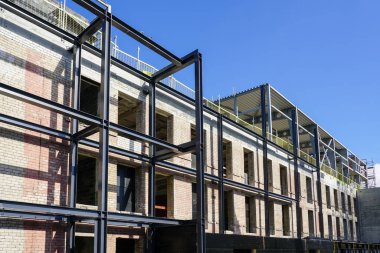 Eski bir tuğla binanın yeniden inşası ve modernizasyonu yeni metal çerçeve yapılarıyla genişletilerek yapılmıştır.