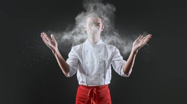 Profesyonel erkek pasta şefi bir restoranın mutfağında havada uçuşan un ile enfes bir yemek hazırlıyor. Yemek ve yemek..