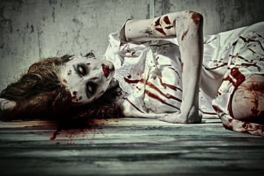 Şeytan tarafından ele geçirilmiş korkunç şekilsiz bir kadın şeytan çıkarma ayininden sonra kanla kaplı karanlık bir odada yatıyor. Ürkütücü zombi kadın. Korku, gerilim. Cadılar Bayramı.