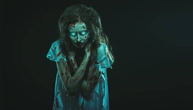 Ürkütücü zombi kadın. Gözleri yanan, şeytan tarafından ele geçirilmiş, korkunç şekilsiz bir kadın karanlıkta duruyor. Korku, gerilim. Cadılar Bayramı.